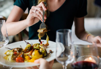 Femme à table qui prend une bouchée avec fourchette