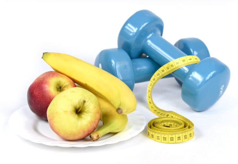 Mode de vie sain: fruits et haltère pour perdre du poids